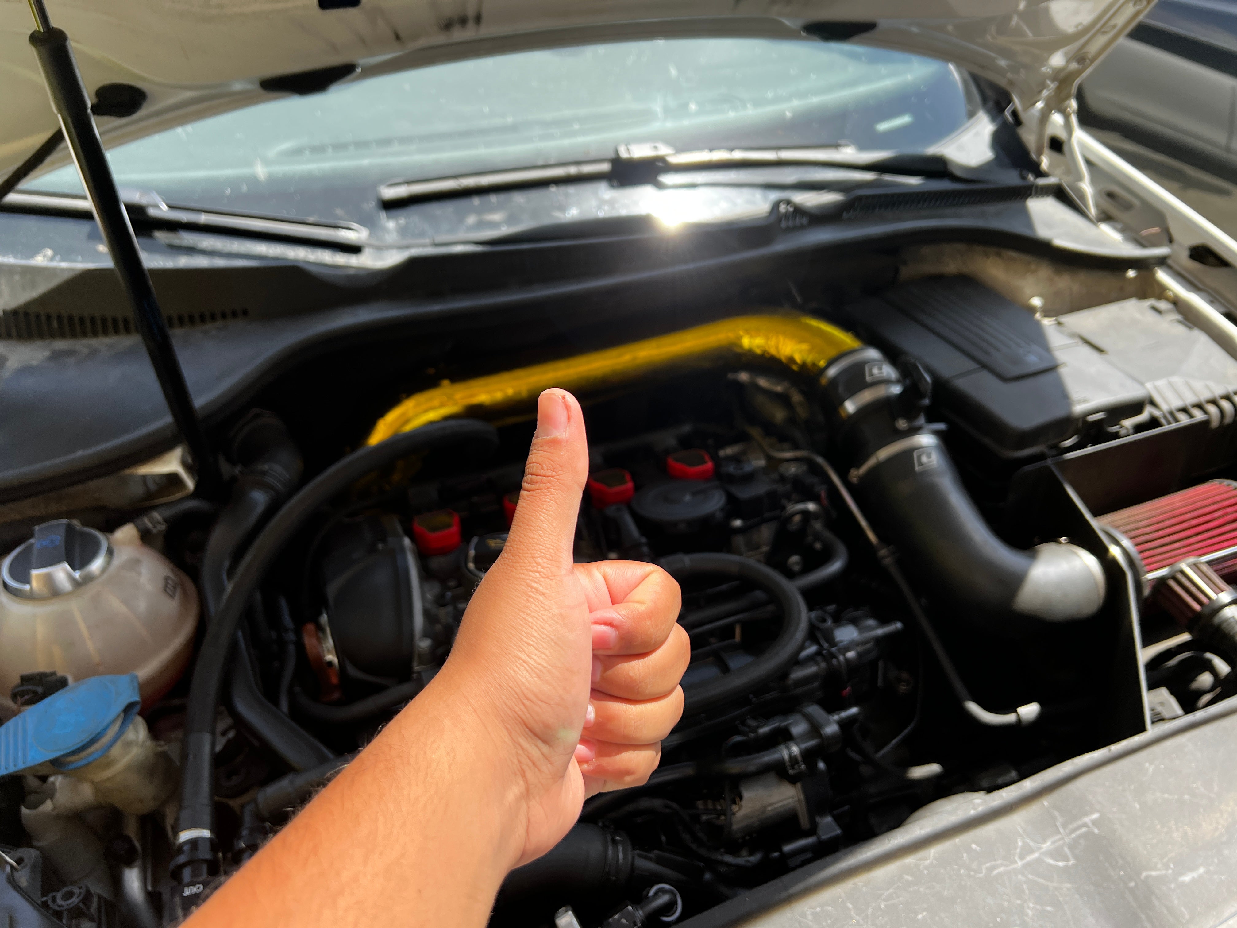 Author giving a thumbs up to the completed engine bay of his repaired GTI.