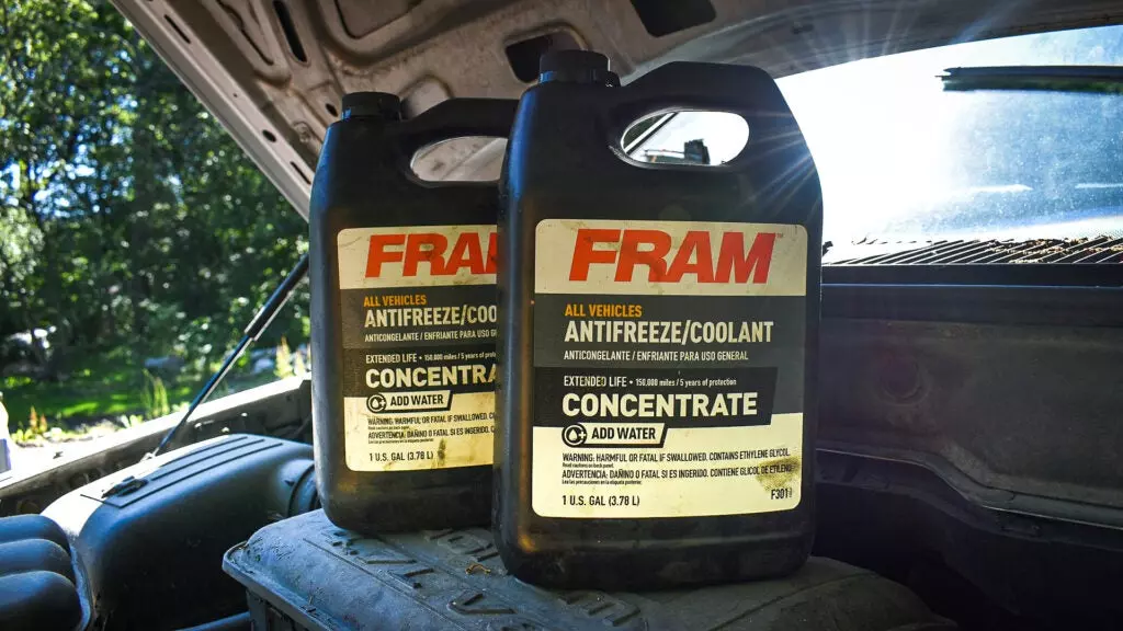 Two containers of Fram antifreeze on top of a '60s Dodge Charger engine block.