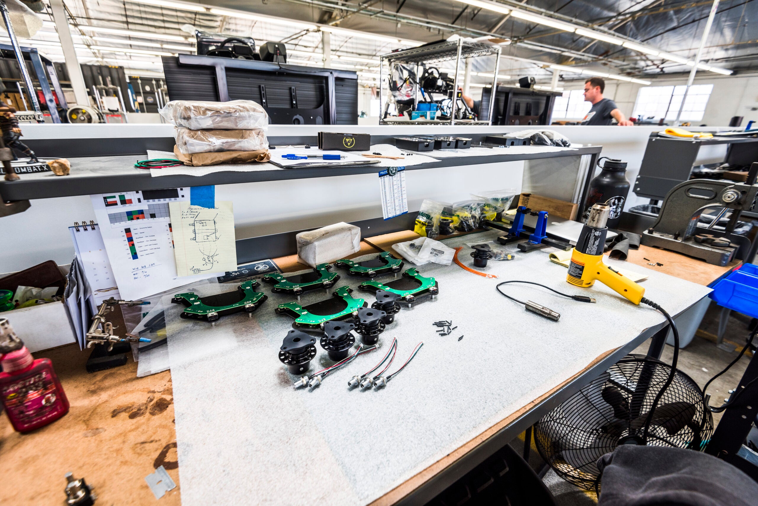 An image of a workbench with various electronic parts on it. The countertop is white.