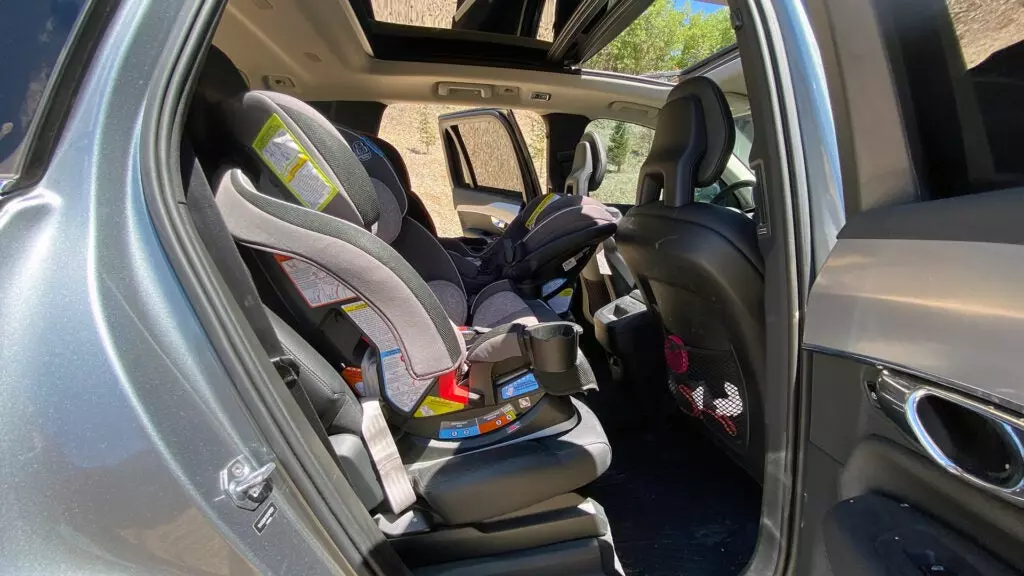 Three car seats in the back of a Volvo XC90 from the point of view of the rear passenger's side door.
