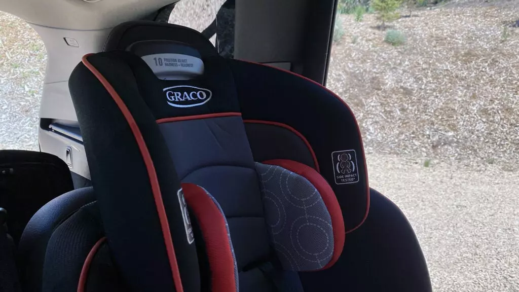 The head rest and bolsters of a child's car seat in the back of a Volvo XC90.