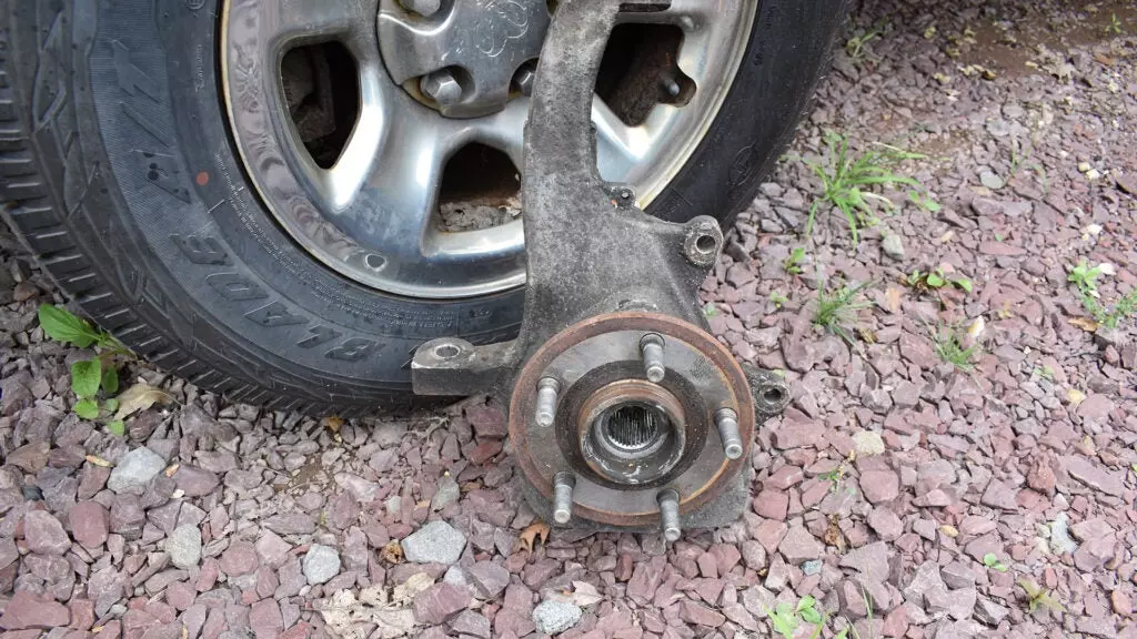 A car's wheel hub leaning on a wheel.