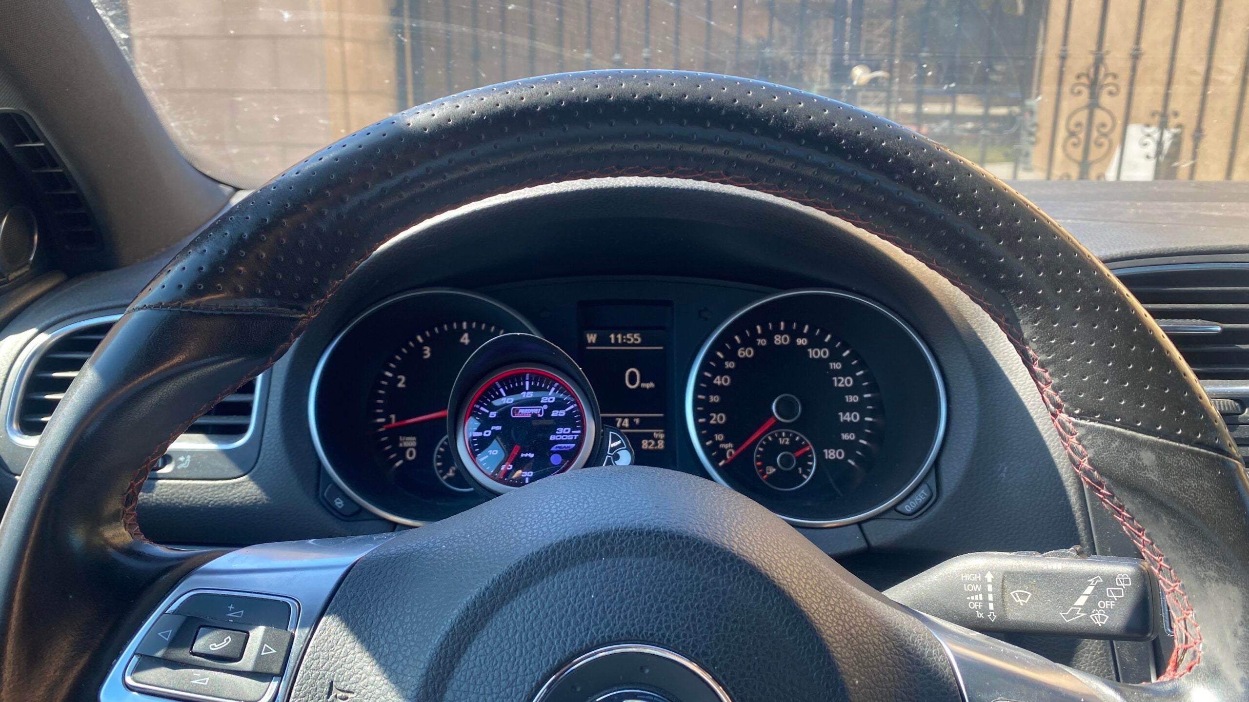 A 2010 VW GTI gauge cluster with a Prosport boost gauge in front of it.