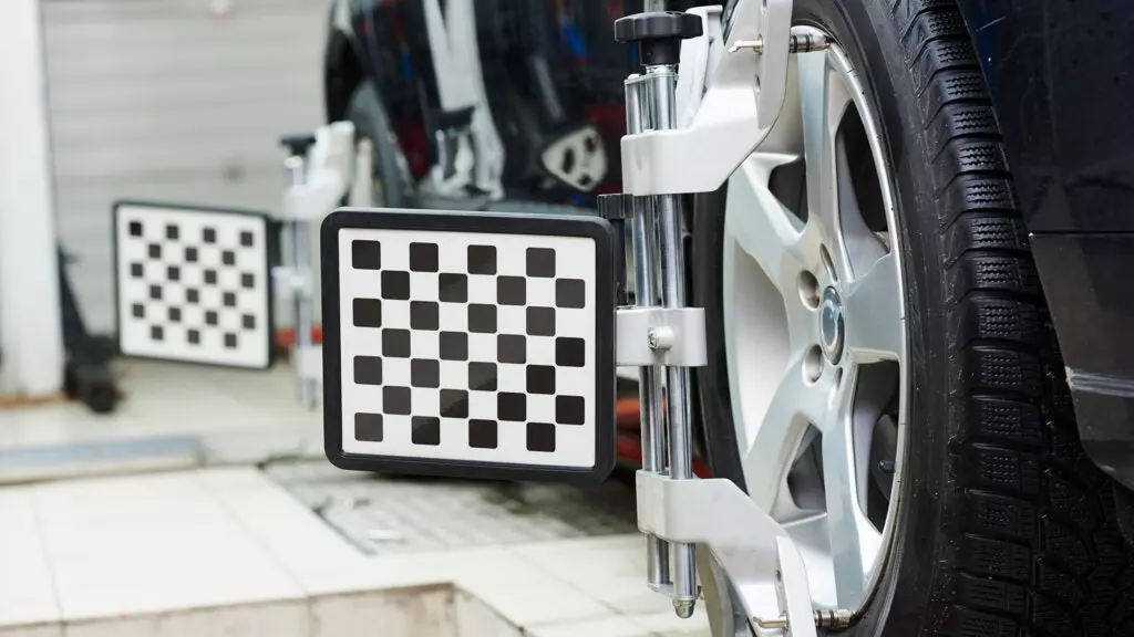 Wheel alignment targets attached to a car's wheels.
