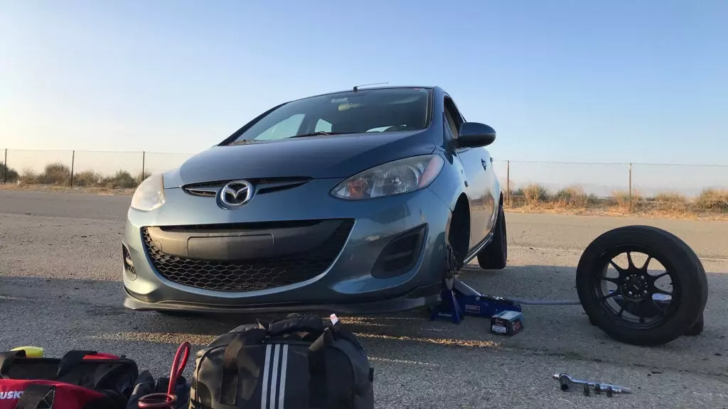 A Mazda 2 lifted by a jack.