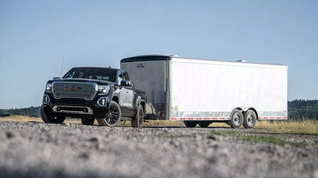 A GMC Sierra tows a box trailer.