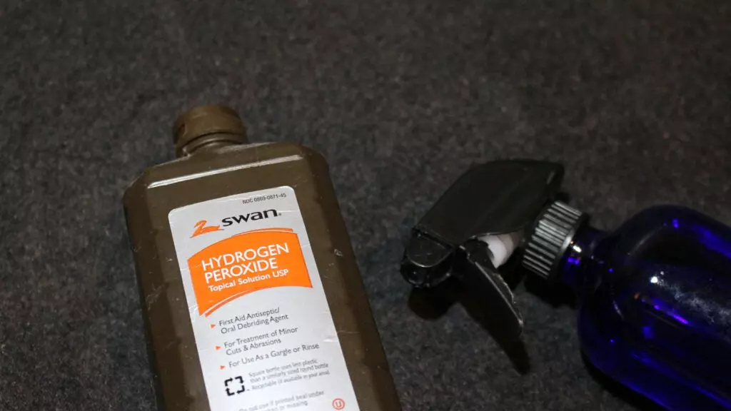 Hydrogen Peroxide next to a glass spray bottle.